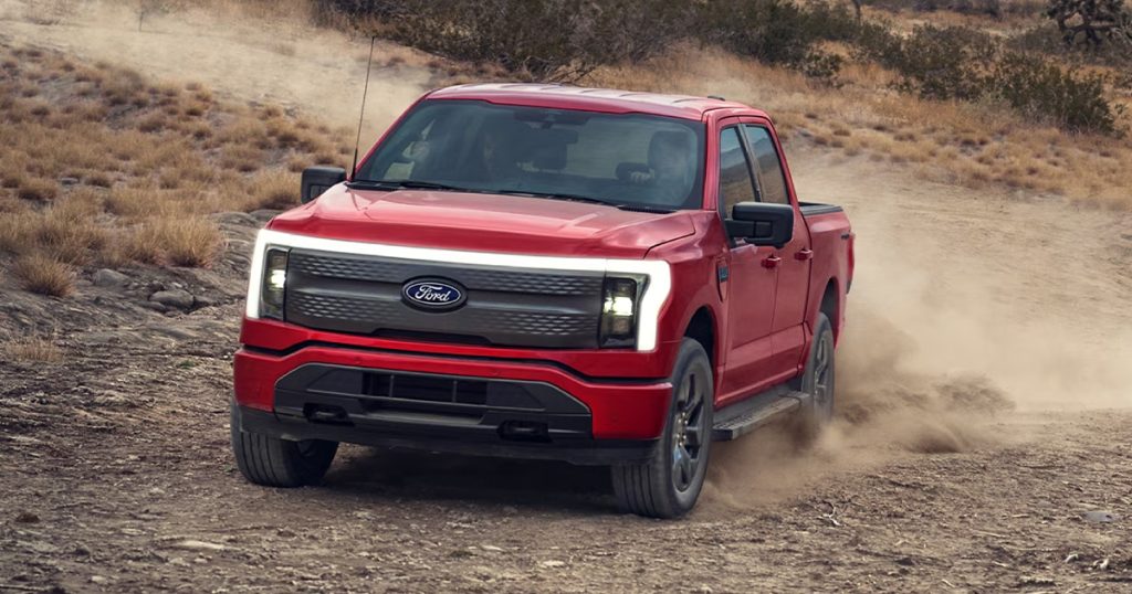 Ford F-150 Lightning in Rapid Red color driving off-road