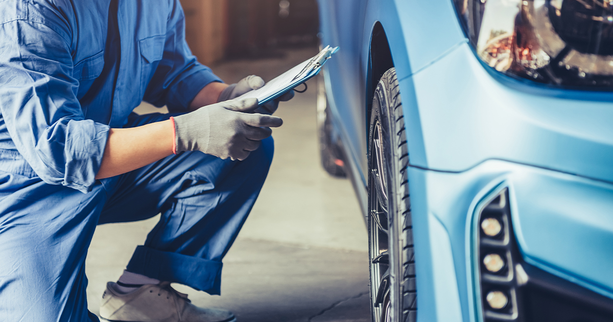 A Ford Service Technician inspecting a vehicle in the service center