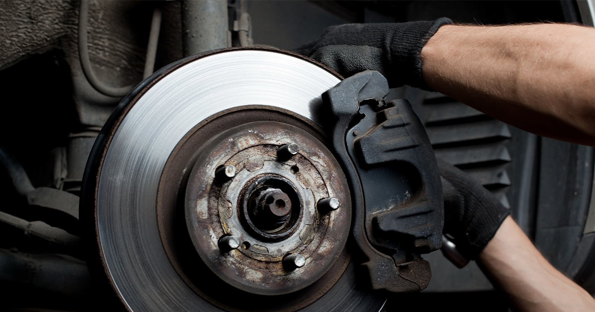 Close-up view of a service technician's hands performing maintenance on a vehicle's brakes